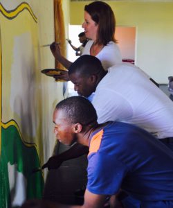 The team painting a mural at Ikwhezi Wefare Organisation