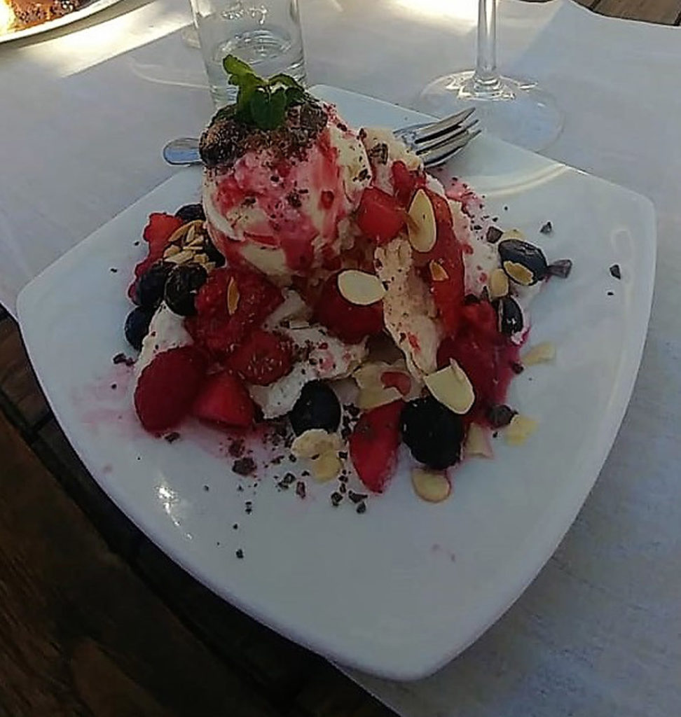70. Food (a): Square white plate with meringue, ice cream berries, nuts, chocolate flakes and sauce